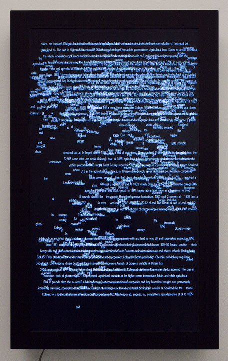 Photographie couleur d’un écran plat posé au mur sur lequel apparaissent des mots et des chiffres générés numériquement. L’ensemble forme une figure abstraite. (Afficher en plein écran)