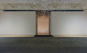 Photographie couleur d’une salle d’exposition dans laquelle de petites bulles descendent du plafond.